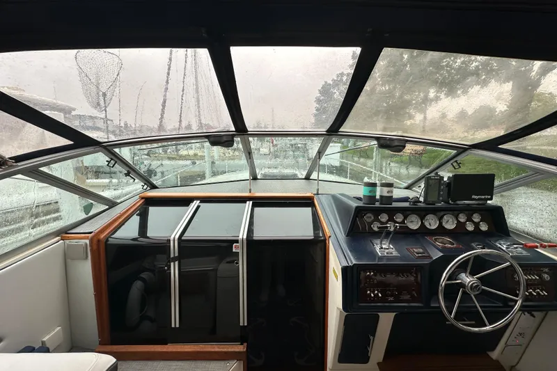 Slide: The Image of 1986 Sea Ray 340 Express Cruiser docked in a marina on a rainy day. - 5