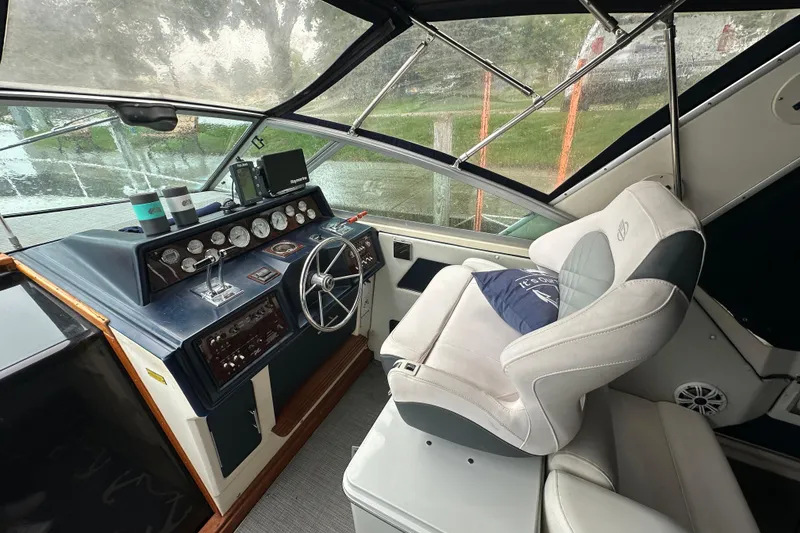 Slide: The Image of 1986 Sea Ray 340 Express Cruiser docked in a marina on a rainy day. - 7
