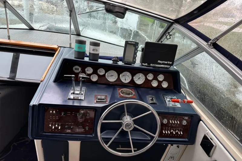 Slide: The Image of 1986 Sea Ray 340 Express Cruiser docked in a marina on a rainy day. - 8