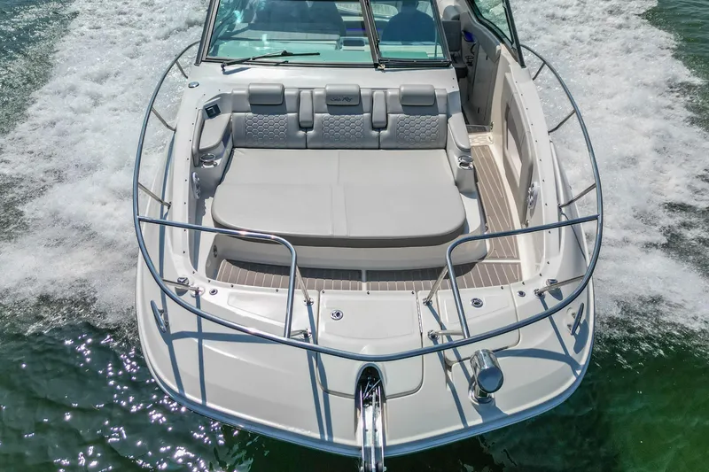 Slide: The Image of 2022 Sea Ray Sundancer 320 Outboard cruising on water, showcasing spacious deck and seating. - 12