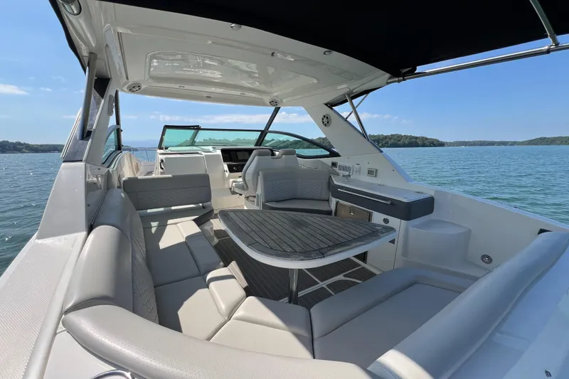 Slide: The Image of Luxurious 2022 Sea Ray Sundancer 320 Outboard boat interior with seating and table on a sunny day. - 33