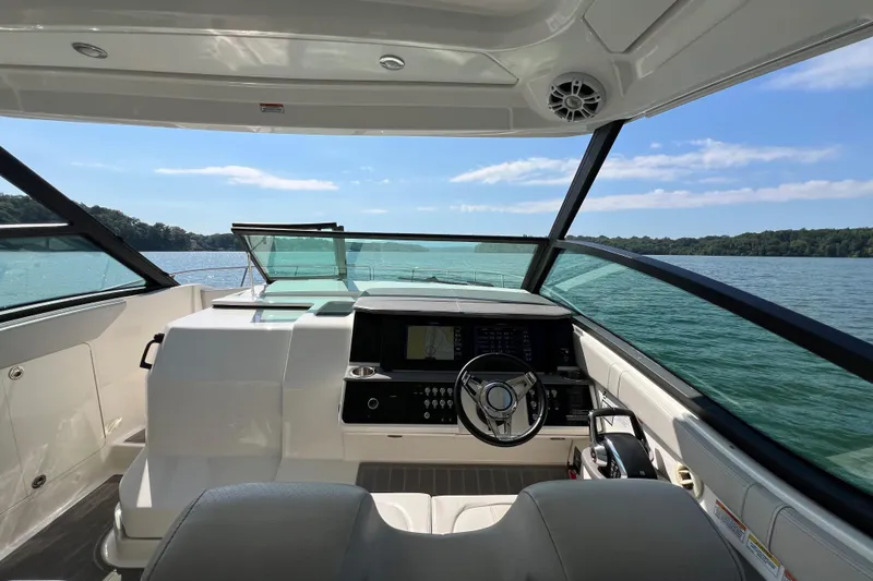 Slide: The Image of 2022 Sea Ray Sundancer 320 Outboard helm with scenic lake view. - 35