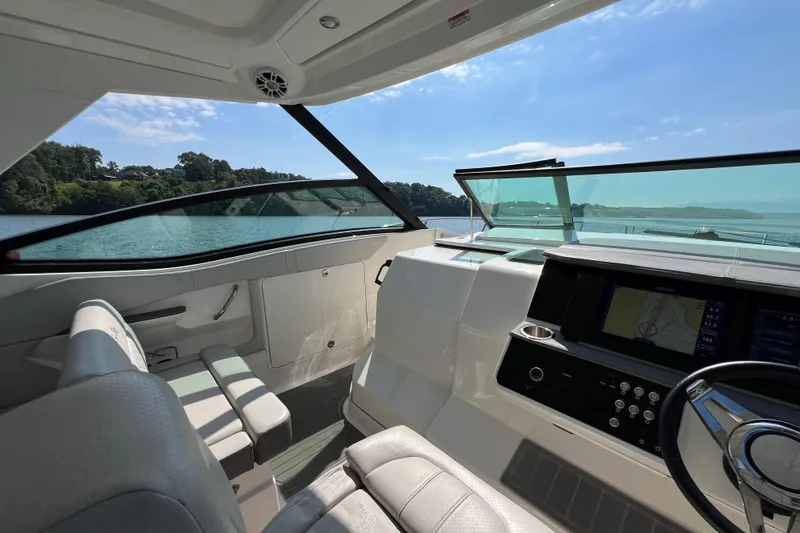 Slide: The Image of 2022 Sea Ray Sundancer 320 Outboard cockpit with modern controls and scenic water view. - 36