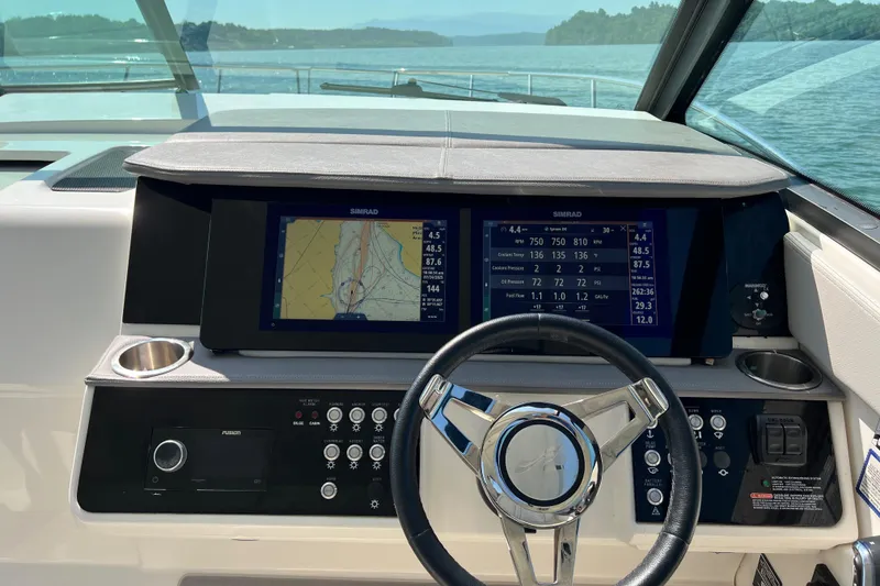 Slide: The Image of 2022 Sea Ray Sundancer 320 Outboard helm with navigation screens and steering wheel. - 37