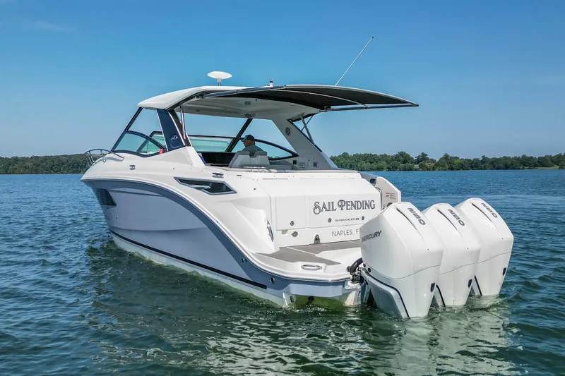 Slide: The Image of 2022 Sea Ray Sundancer 320 Outboard cruising on a calm lake under clear blue skies. - 4