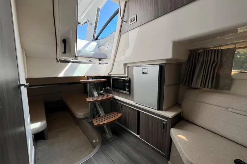 Slide: The Image of Interior of 2022 Sea Ray Sundancer 320 Outboard, featuring modern kitchenette and seating area. - 40