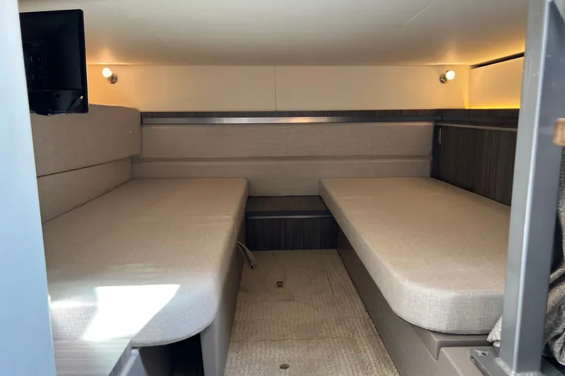 Slide: The Image of 2022 Sea Ray Sundancer 320 Outboard cabin interior with beige seating and modern lighting. - 43