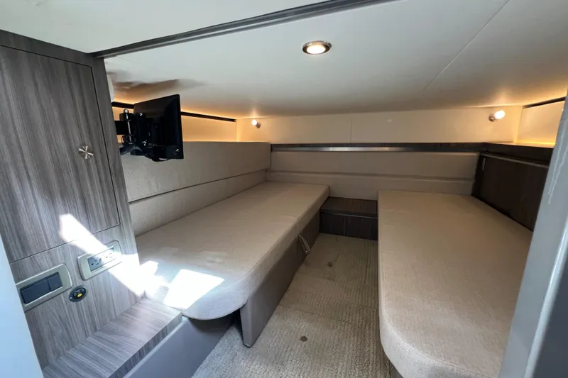 Slide: The Image of 2022 Sea Ray Sundancer 320 Outboard cabin interior with modern seating and wall-mounted TV. - 45