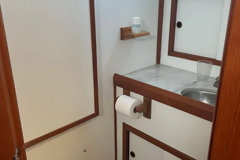 Slide: The Image of 1986 Monk 36 Trawler bathroom with sink, wooden accents, and storage. - 15