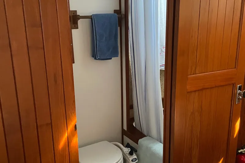 Slide: The Image of Wood-paneled bathroom on 1986 Monk 36 Trawler with towel and shower curtain. - 18
