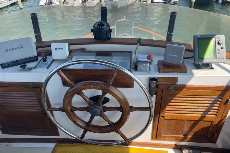 Slide: The Image of 1986 Monk 36 Trawler helm with wooden wheel, navigation equipment, and marine electronics. - 5