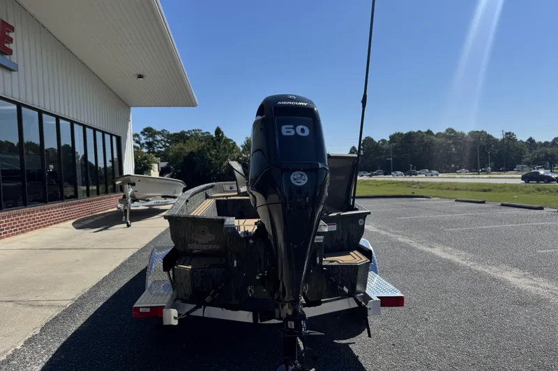 Slide: The Image of 2026 Tracker Grizzly 1650 T Prairie Wings Edition boat with Mercury 60 engine in parking lot. - 12