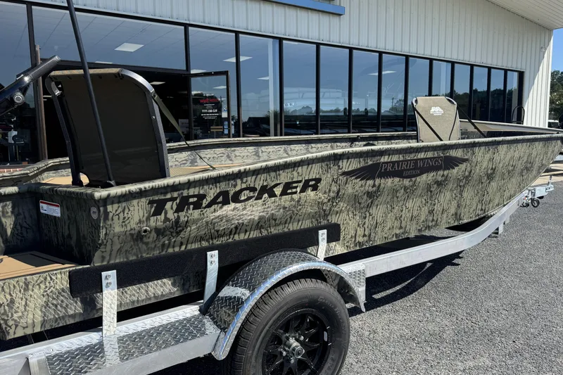 Slide: The Image of 2026 Tracker Grizzly 1650 T Prairie Wings Edition boat on a trailer outside a showroom. - 2