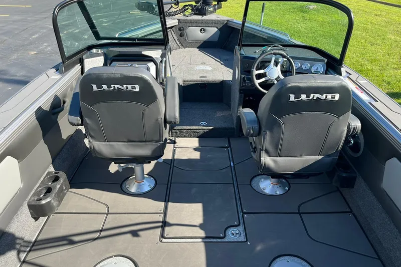 Slide: The Image of 2026 Lund 2275 Baron boat interior with dual seats and steering wheel. - 11