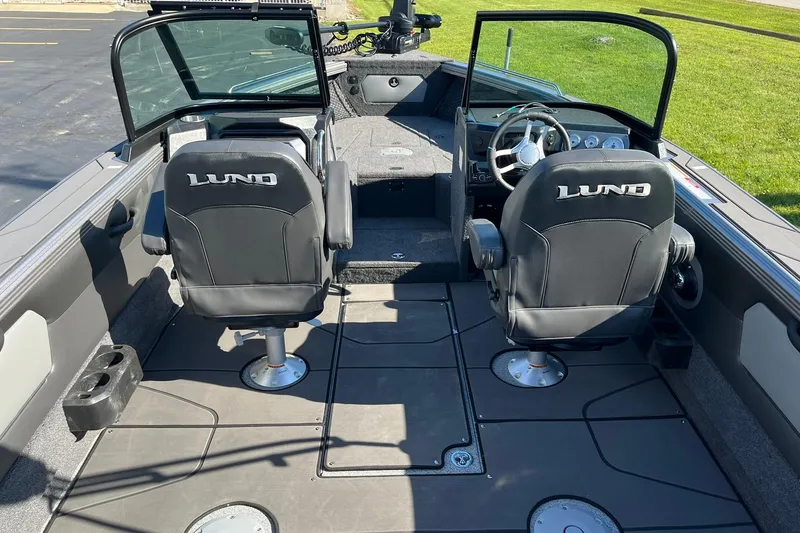 Slide: The Image of 2026 Lund 2275 Baron boat interior with two black seats and steering console. - 15