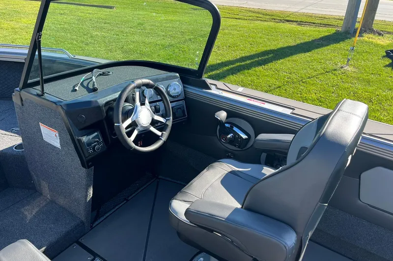 Slide: The Image of 2026 Lund 2275 Baron boat interior with steering wheel and captain's seat. - 17