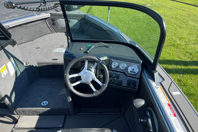 Slide: The Image of 2026 Lund 2275 Baron boat interior with steering wheel and dashboard controls. - 18