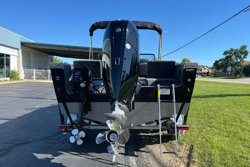 Slide: The Image of 2026 Lund 2275 Baron boat rear view with dual outboard motors and ladder. - 2