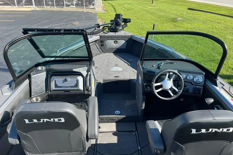 Slide: The Image of 2026 Lund 2275 Baron boat interior with steering wheel, seating, and dashboard controls. - 23