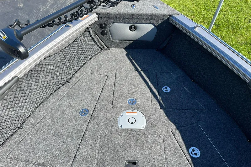 Slide: The Image of 2026 Lund 2275 Baron boat interior with carpeted deck and storage compartments. - 24