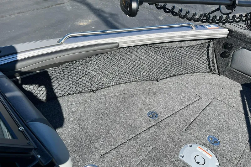 Slide: The Image of 2026 Lund 2275 Baron boat interior with carpeted flooring and storage netting. - 28