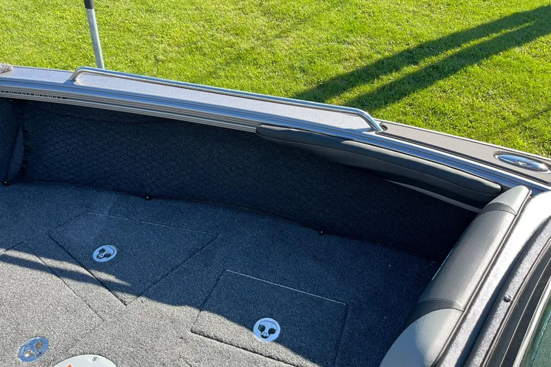 Slide: The Image of 2026 Lund 2275 Baron boat interior with cushioned seating and carpeted flooring. - 29