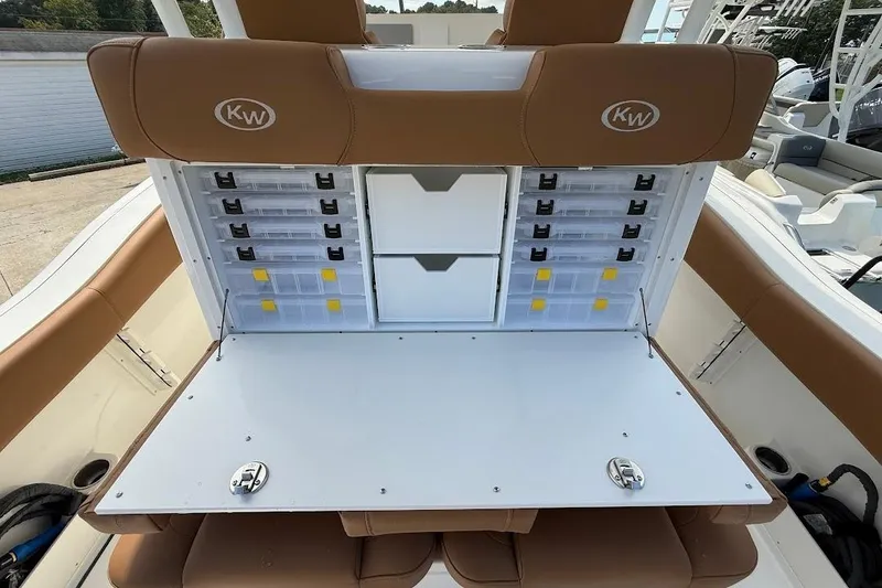 Slide: The Image of 2026 Key West 291 FS boat with open storage compartments and tan seating. - 12