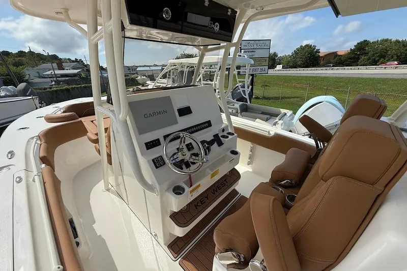 Slide: The Image of 2026 Key West 291 FS boat interior with Garmin navigation and brown leather seating. - 14