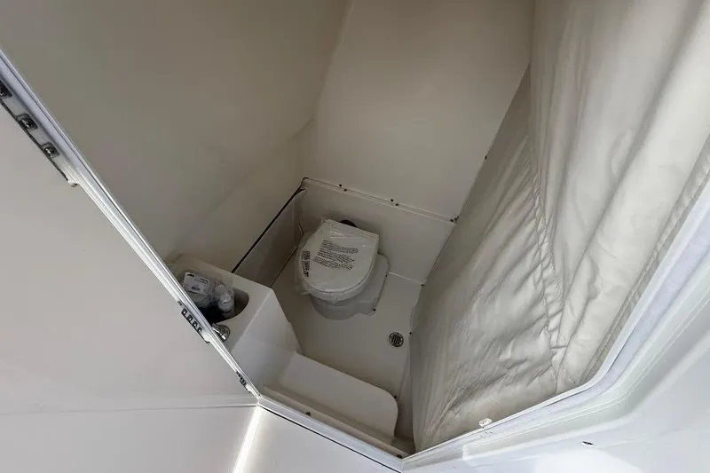Slide: The Image of Interior of 2026 Key West 291 FS boat bathroom with compact toilet and shower. - 21