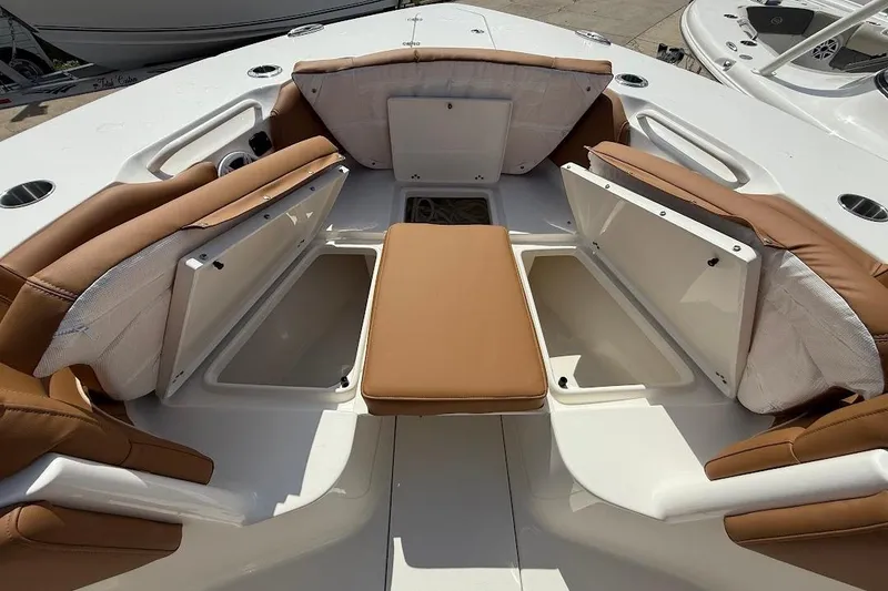 Slide: The Image of 2026 Key West 291 FS boat interior with tan cushioned seating and storage compartments. - 26