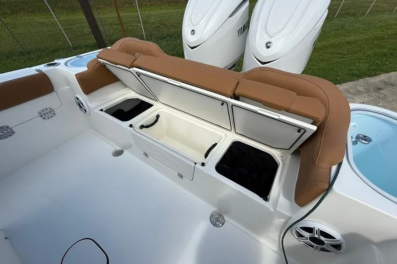 Slide: The Image of 2026 Key West 291 FS boat with open storage compartments and tan seating. - 8