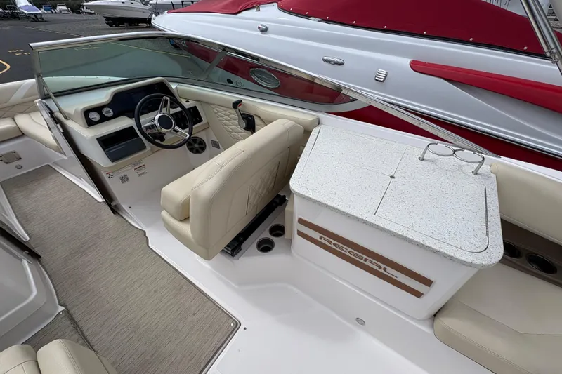 Slide: The Image of 2018 Regal 26 OBX boat interior with beige seating and SunDeck branding. - 11