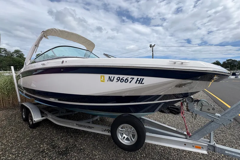 Slide: The Image of 2018 Regal 26 OBX boat on trailer, NJ 9667 HL, parked outdoors. - 2