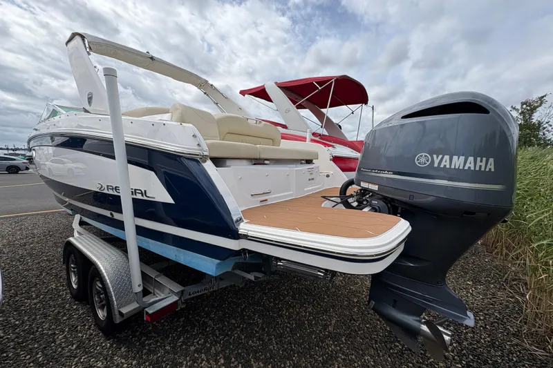 Slide: The Image of 2018 Regal 26 OBX boat with beige seating and sleek design, docked among other boats. - 7