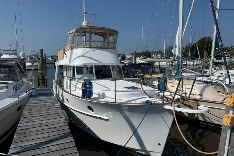 Slide: The Image of 2007 Beneteau Swift Trawler 42 docked at marina, surrounded by other boats. - 2