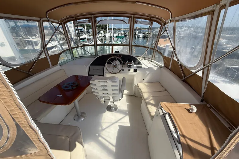 Slide: The Image of 2007 Beneteau Swift Trawler 42 helm with seating, table, and marina view. - 24