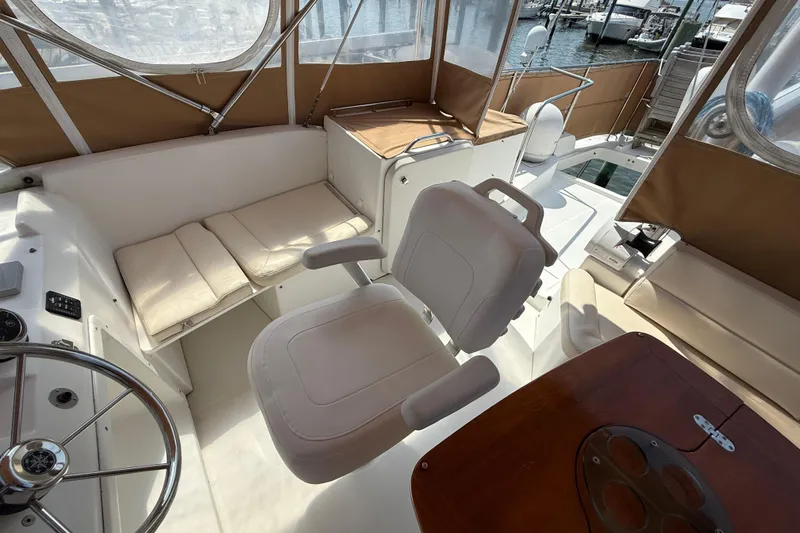 Slide: The Image of 2007 Beneteau Swift Trawler 42 interior with helm, seating, and wooden table. - 26