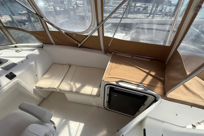 Slide: The Image of 2007 Beneteau Swift Trawler 42 interior with seating and mini fridge, enclosed by clear panels. - 27