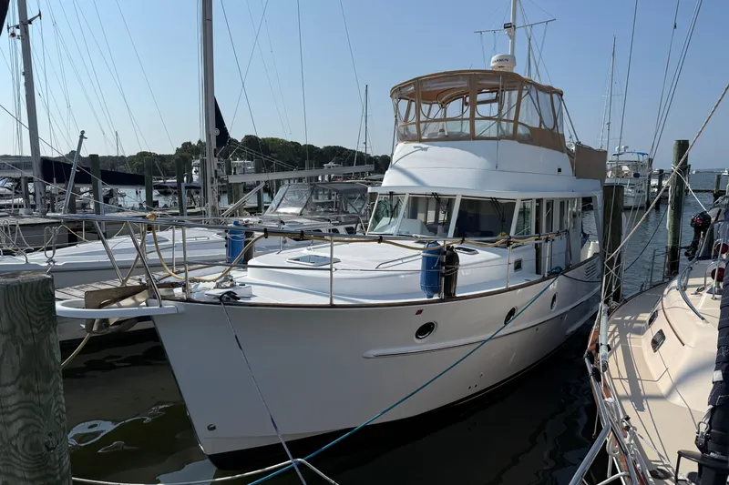 Slide: The Image of 2007 Beneteau Swift Trawler 42 docked at a marina, surrounded by sailboats. - 3