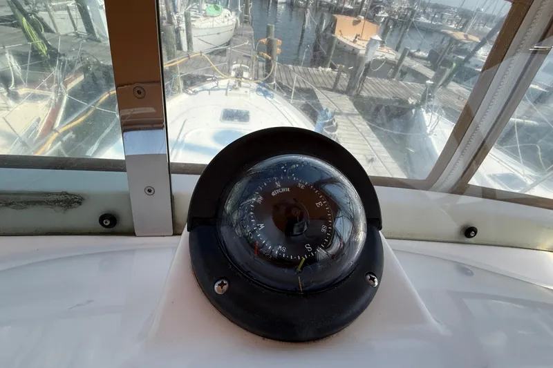 Slide: The Image of Compass on 2007 Beneteau Swift Trawler 42, docked at marina with boats in background. - 33