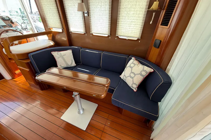 Slide: The Image of Luxurious interior of 2007 Beneteau Swift Trawler 42 with navy seating and wooden table. - 35