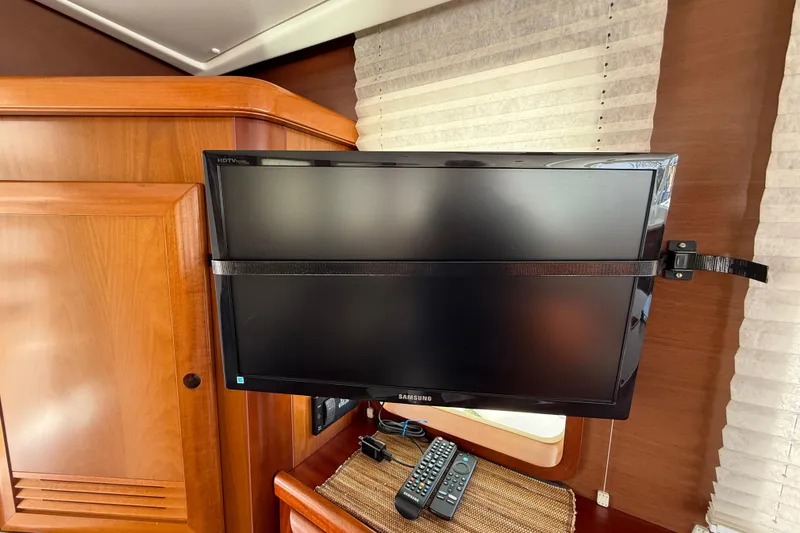 Slide: The Image of Samsung HDTV mounted in 2007 Beneteau Swift Trawler 42 interior with remote controls. - 41