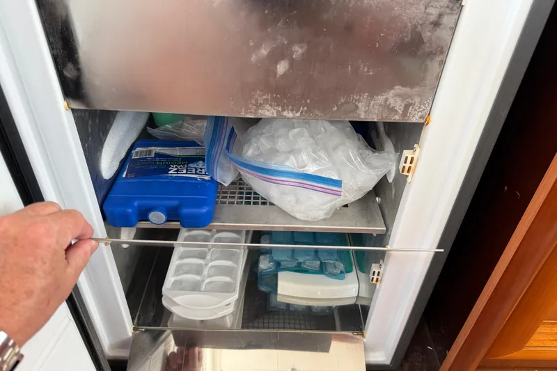 Slide: The Image of Open freezer on 2007 Beneteau Swift Trawler 42, containing ice packs and trays. - 48