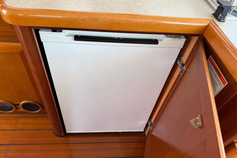 Slide: The Image of 2007 Beneteau Swift Trawler 42 interior with open wooden cabinet and built-in refrigerator. - 49