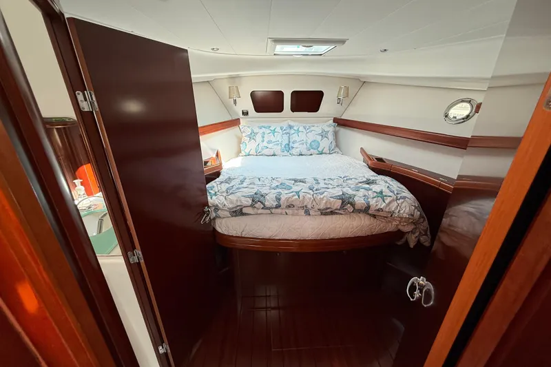 Slide: The Image of 2007 Beneteau Swift Trawler 42 cabin with cozy bed and elegant wood finish. - 58