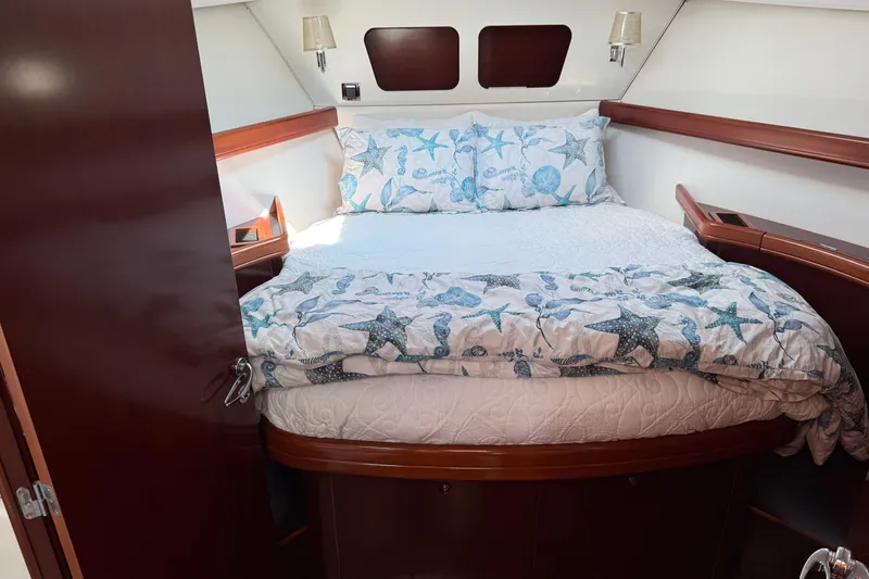 Slide: The Image of Cozy bedroom in 2007 Beneteau Swift Trawler 42 with nautical-themed bedding. - 59