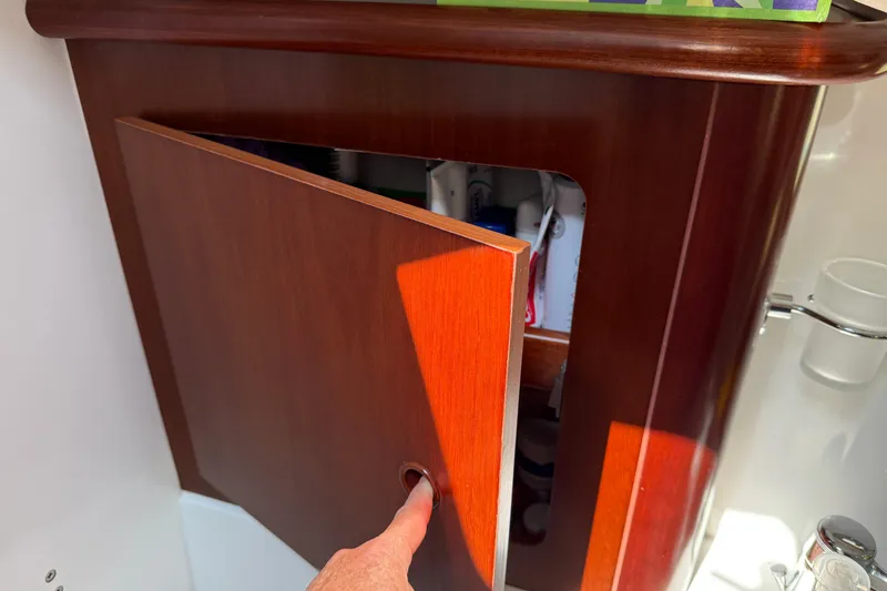 Slide: The Image of Wooden cabinet door on 2007 Beneteau Swift Trawler 42, partially open with visible contents. - 66