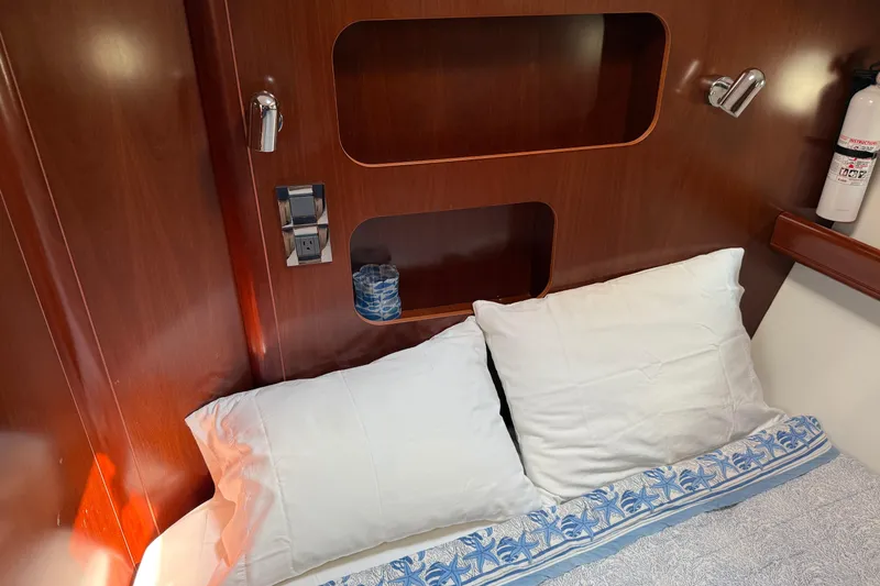 Slide: The Image of Cozy cabin interior of 2007 Beneteau Swift Trawler 42 with pillows and wooden shelving. - 68