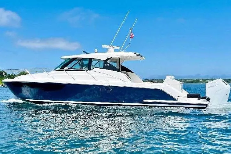 Slide: The Image of 2023 Tiara Yachts 43 LS cruising on clear blue waters under a sunny sky. - 0