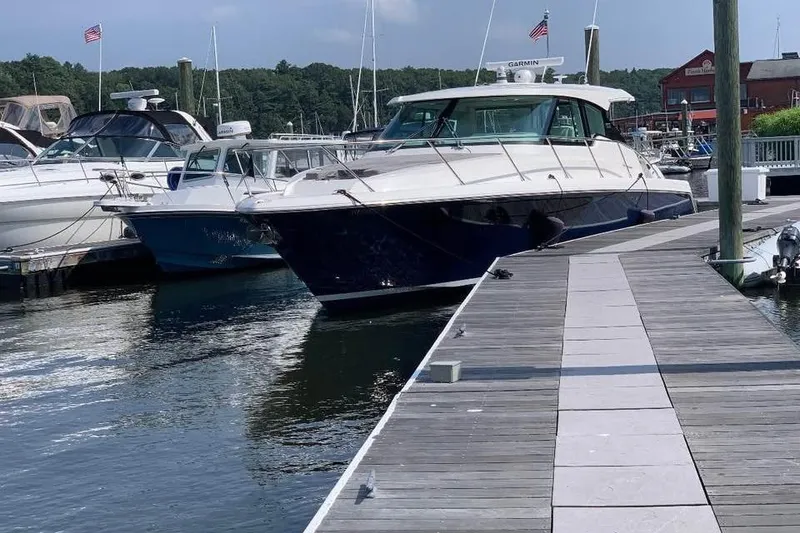 Slide: The Image of 2023 Tiara Yachts 43 LS docked at a marina with other boats. - 1